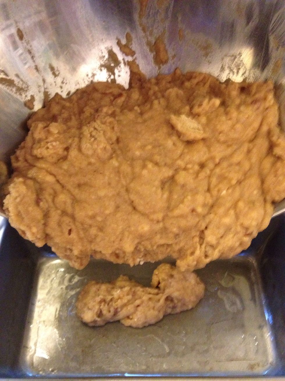Use a spatula to scrape batter from the bowl into the greased loaf pan.