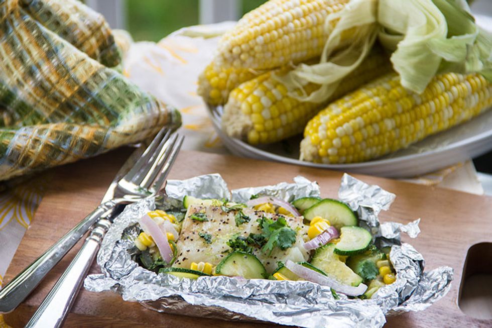 Use a spatula to transfer the packets to plates, flipping so that they're right-side-up again, with fish on top. Cut a slit into the top center to peel back the foil (careful: steam is very hot).