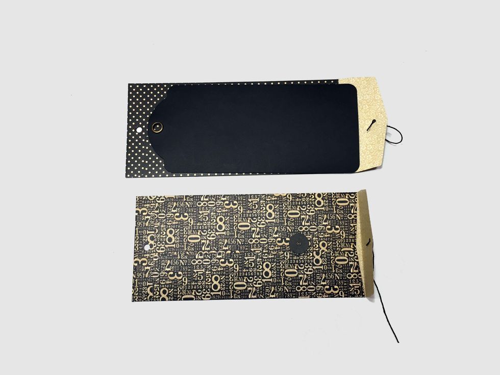 Use a tag to mark & punch holes in the ends of the envelopes.  Save the binder ring from the tags for assembly.  Shorten 2 of the tags to 8 3/8" so they'll fit in the envelopes above the punched hole.