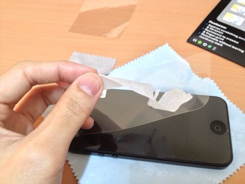 Use a tape to remove the old screen protector (if it has one) on your Iphone