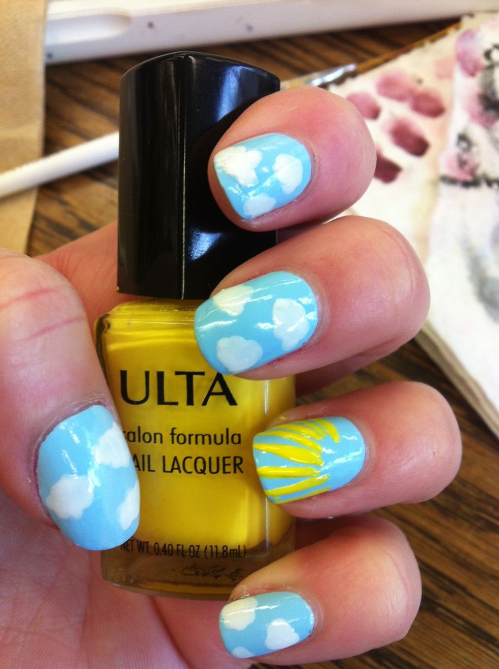 Use a thin brush and yellow polish to paint straight lines radiating from one corner of your nail. These will be the rays for your sunshine!