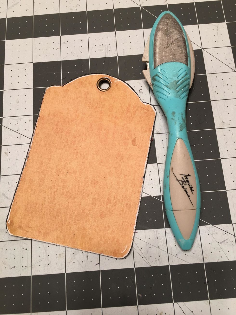 Use a tool to distress the edges of the tag on the front and back.