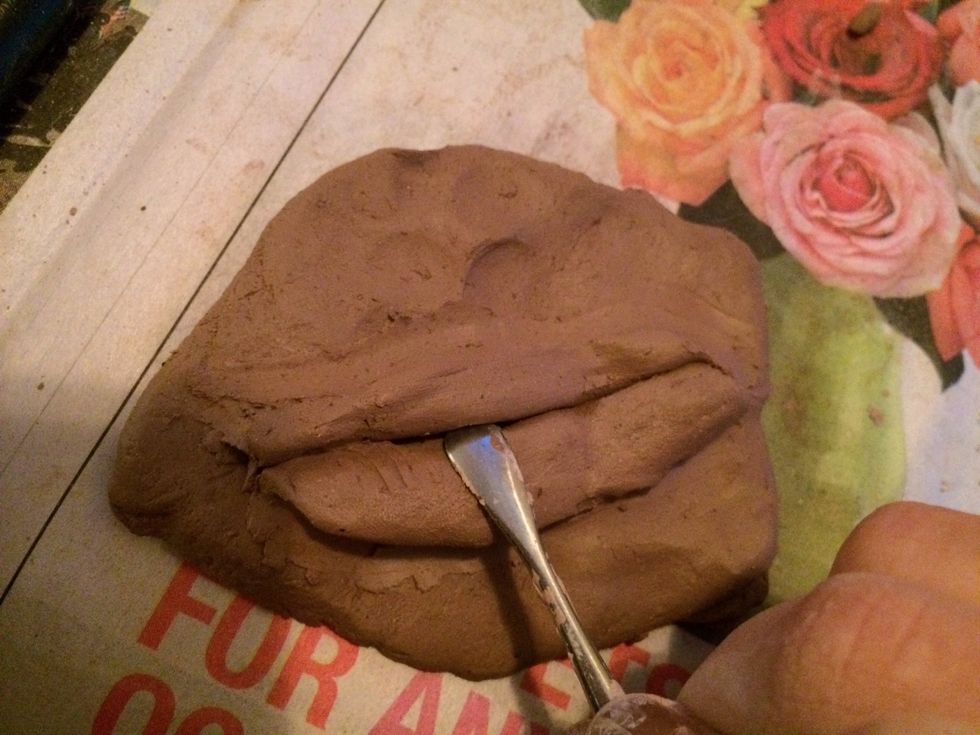 Use a tool to start sculpting the roundness of the lips. Round out both lips at the center.