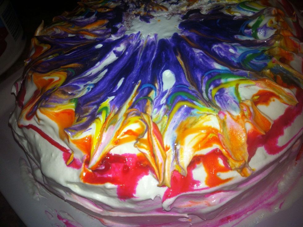 Use a toothpick or skewer to create tie dye design starting from the middle and dragging it towards the outside of your cake.