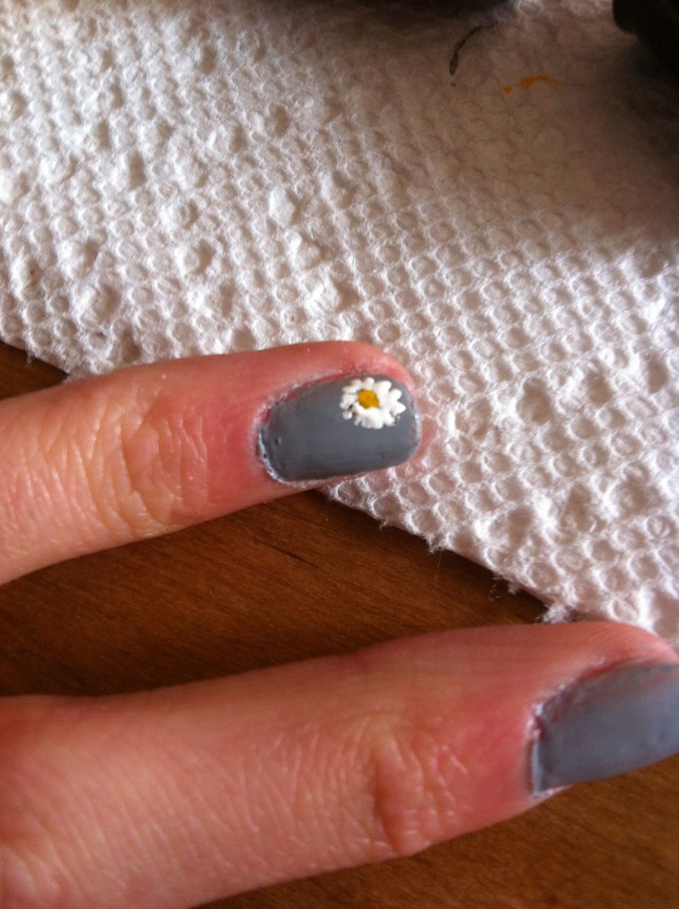 Use a white striper or nail polish pen to add little petals around the yellow dot.