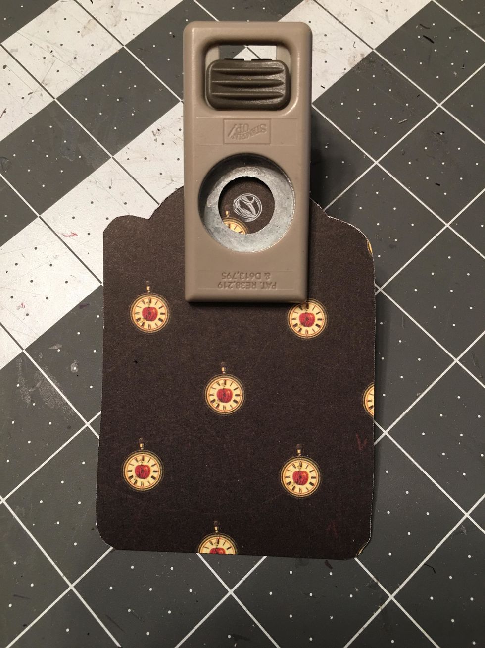 Use an 1/2" hole punch to punch out the hole for the grommet of the tag. Center the mark as best you can and punch out.
