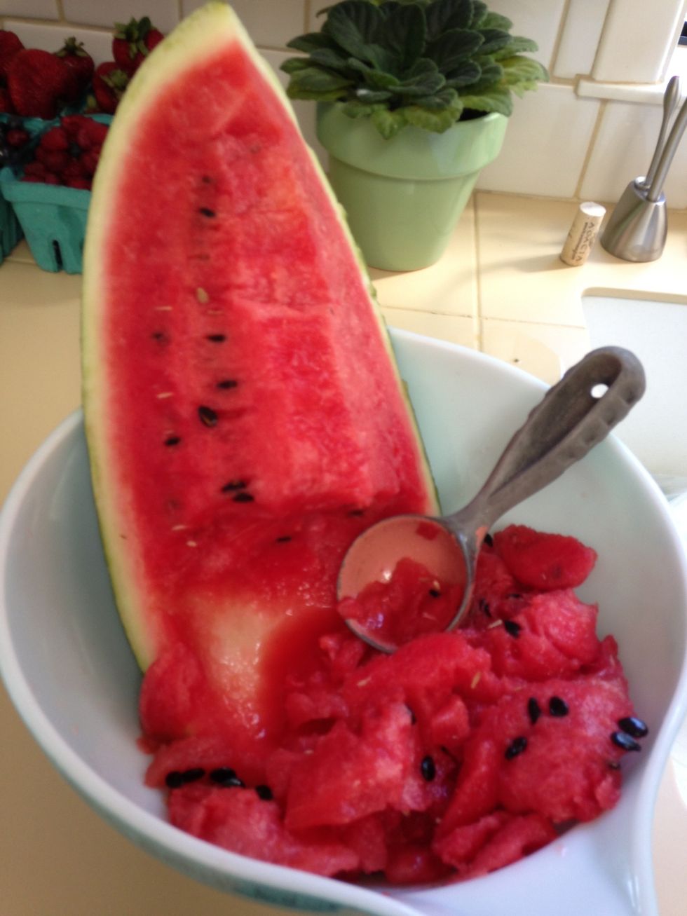 Use an ice cream scoop to scoop out the red meat of the watermelon. Put all of it in a bowl, which will be frozen overnight in freezer.
