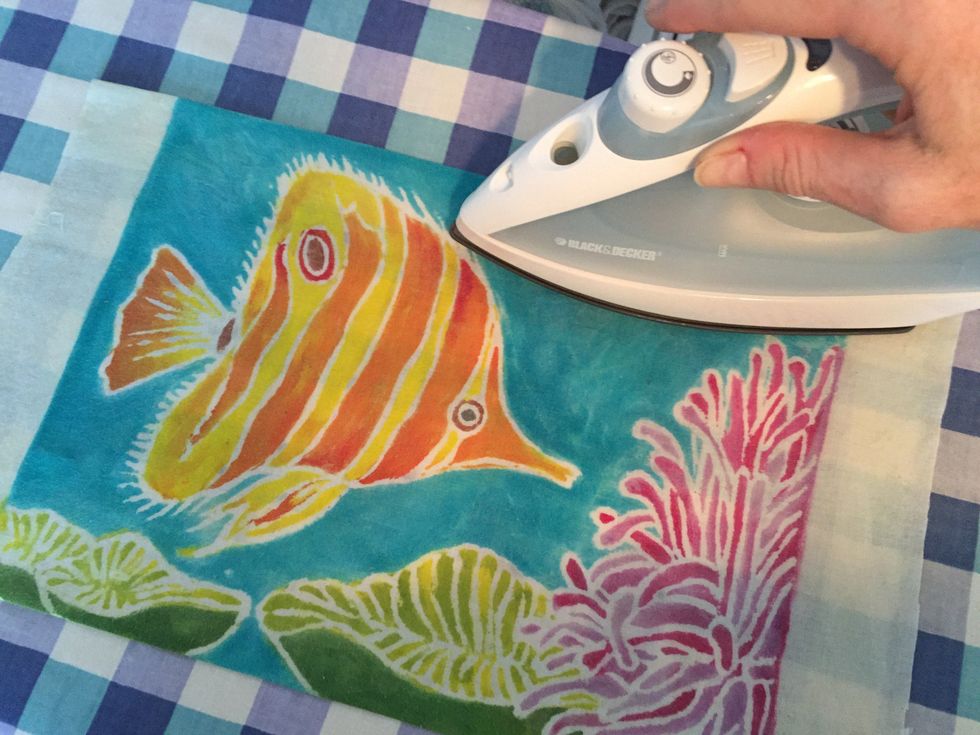 Use an iron to press the borders under. If you have painted a neat edge, you can leave a bit of the plain muslin showing to create a white border. You may also sew on some beads after this step.