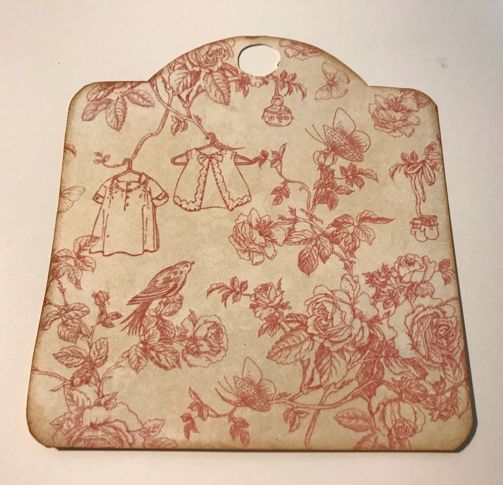 Use an Ivory tag and trace the tag on the pink floral paper. Cut tag out. Punch circle at top of paper using 1/2" circle punch. Ink edges of tag using Vintage Photo Ink & blending tool with foam.