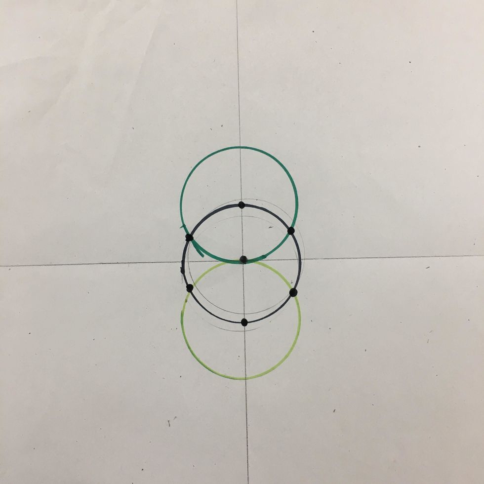 Use another color marker to create a 3rd circle. Line up the cup to make a circle below the first circle. Line the top of the cup with the center dot. Mark dots on all points where circles touch.