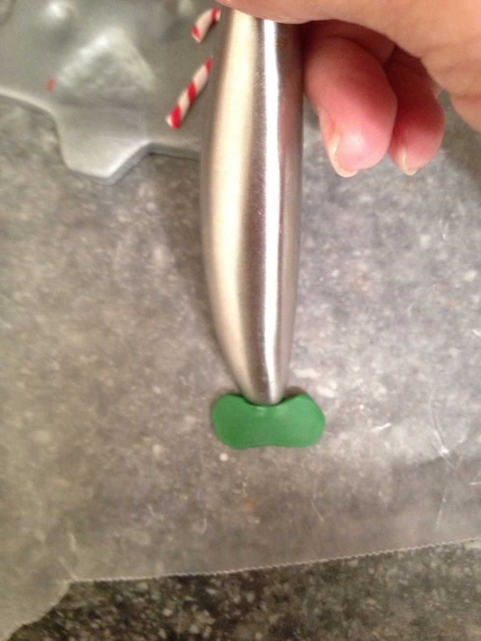 Use another color to make more embellishments. Here, I made a bone by using the end of a knife to make indentions. Use a toothpick to make a dent in the center of the bone.