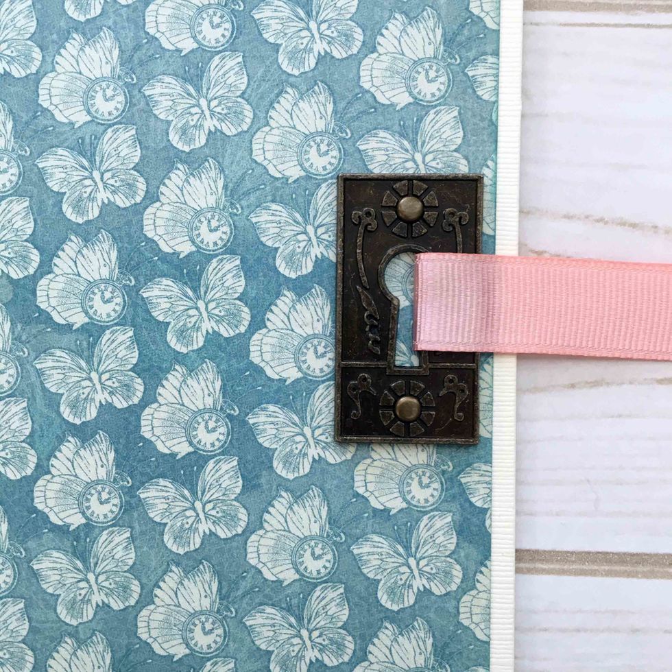 Use brads to secure the keyhole on the left side of the front cover, centering from top to bottom.  It should be about 3 1/2" from the top.