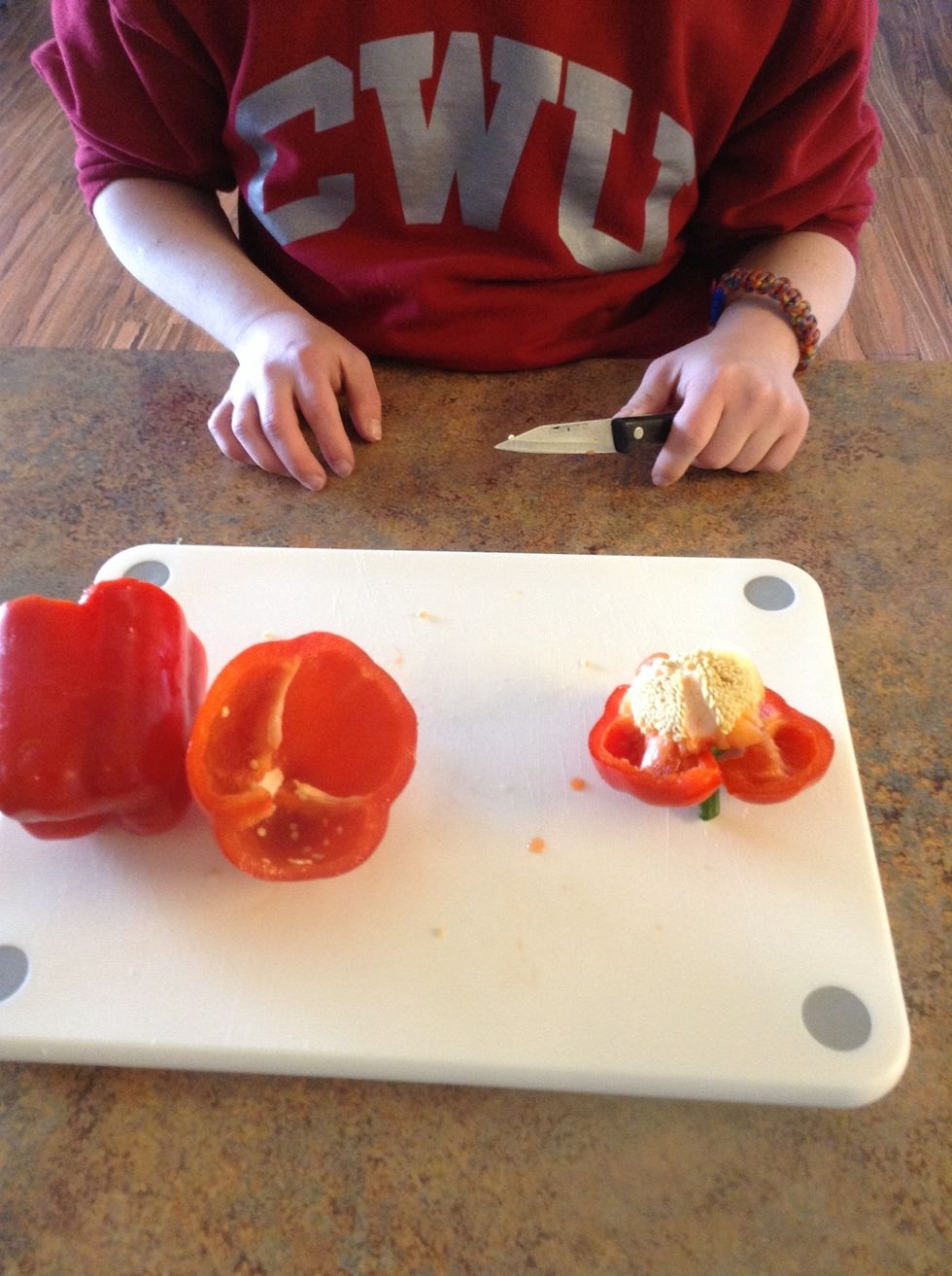 Use cutting board and knife and cut the top off the red peppers