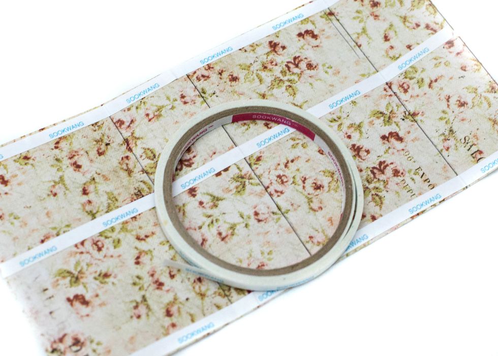 Use double-sided adhesive to adhere the paper to the box. Be sure to put the adhesive on the opposite side you want shown.