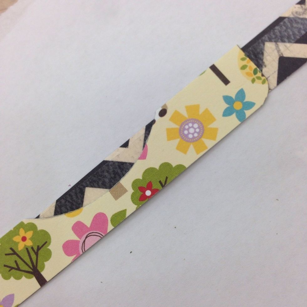 Use double sided adhesive to layer black strip on top of green strip. Turn over and trim away the sections of the black strip strip that extend past the green strip: top and bottom edges, curved area.