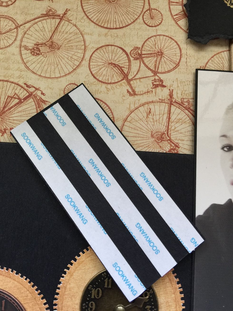Use double-sided tape to stick a black cardboard just above of the other piece of cardboard.
