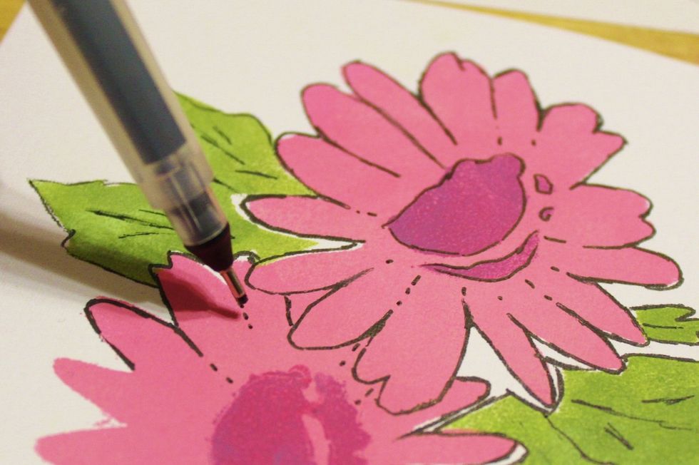 use fine tipped black pen to loosely outline stenciled flowers...