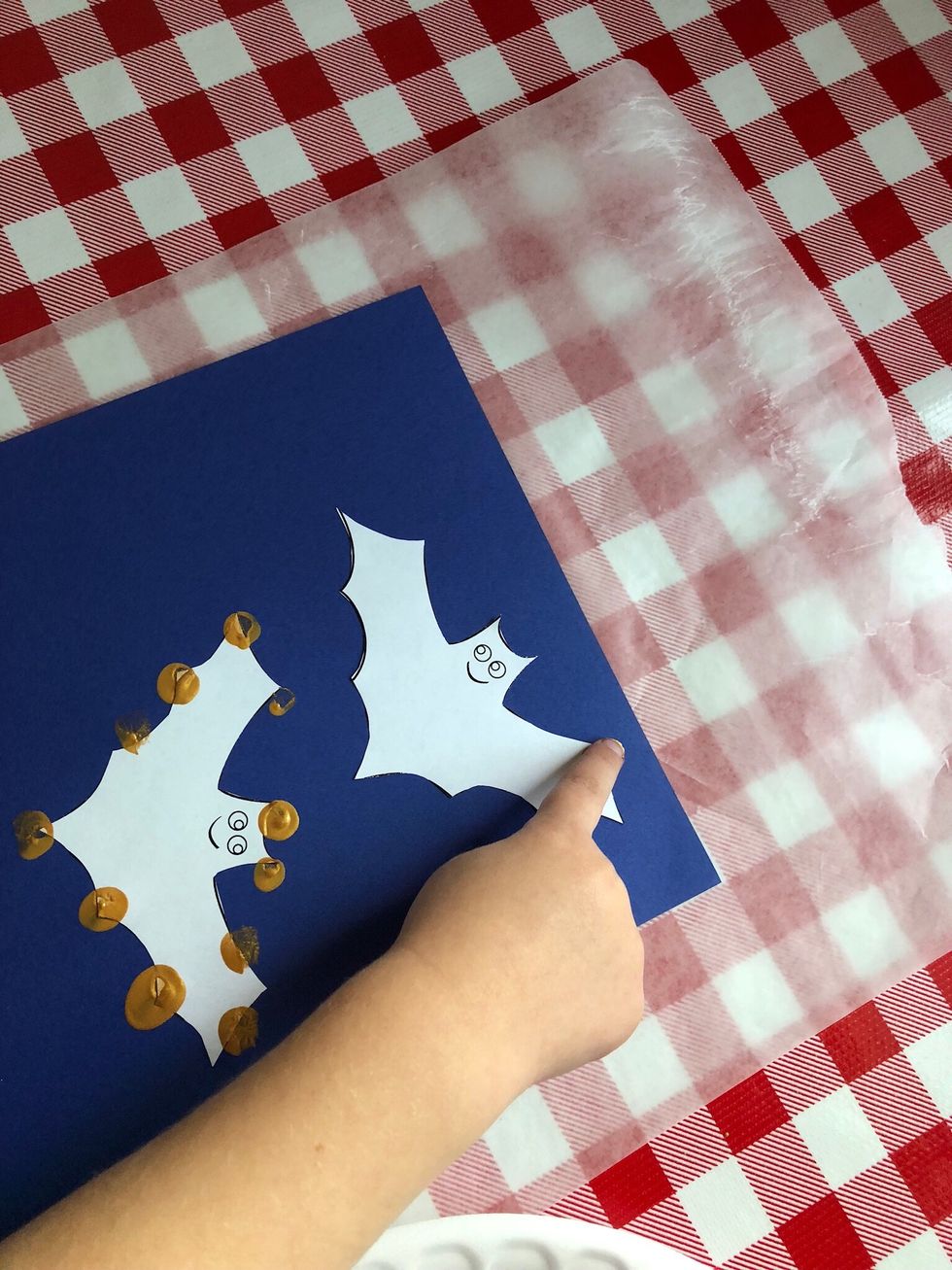 Use finger to dip in paint and make fingerprint along edge of bat. Fill in solid painted fingerprints along edge of bats.