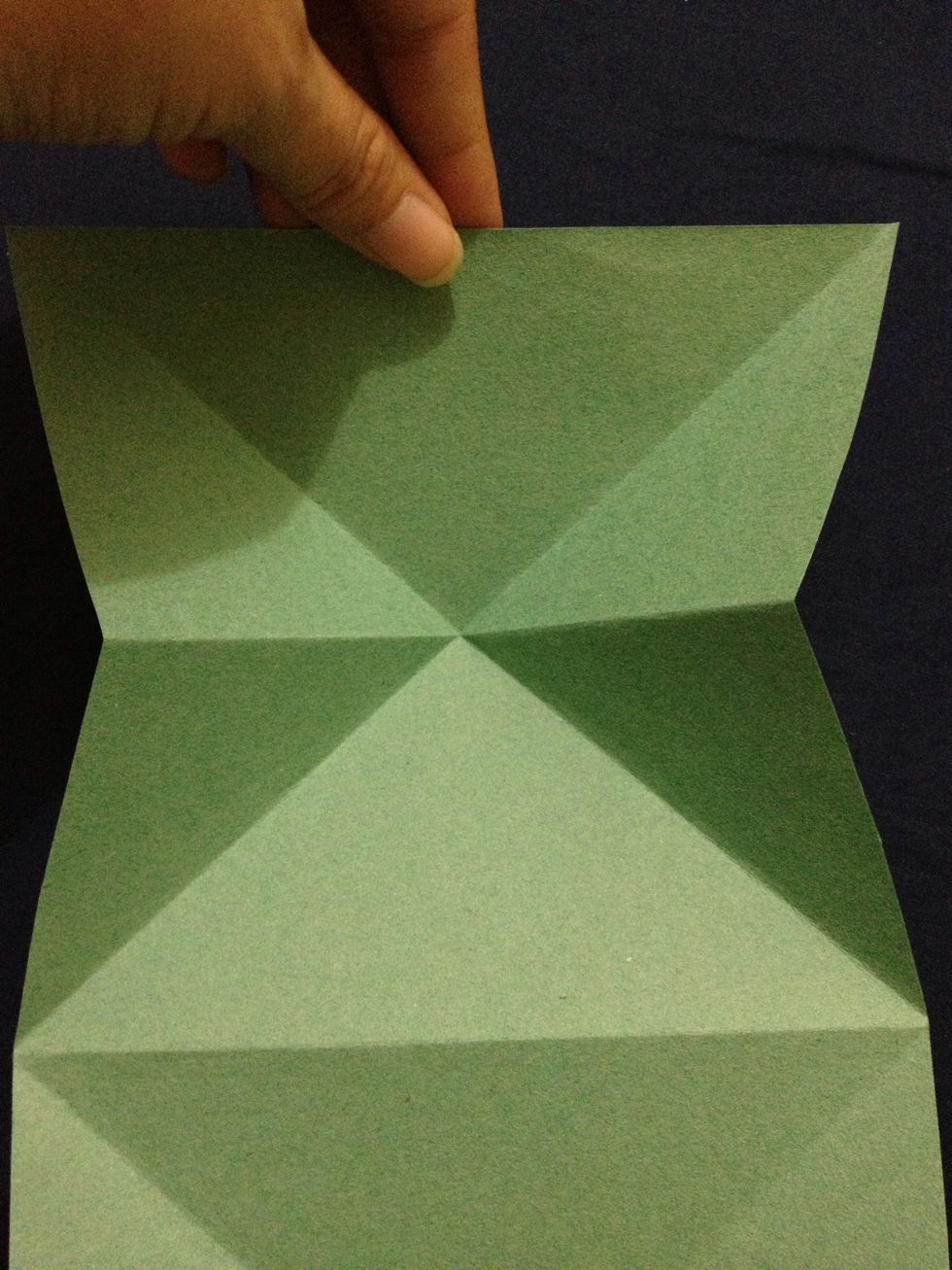 Use finger to hold the top centre, slowly fold inward, the crease will guide you to form a triangle...