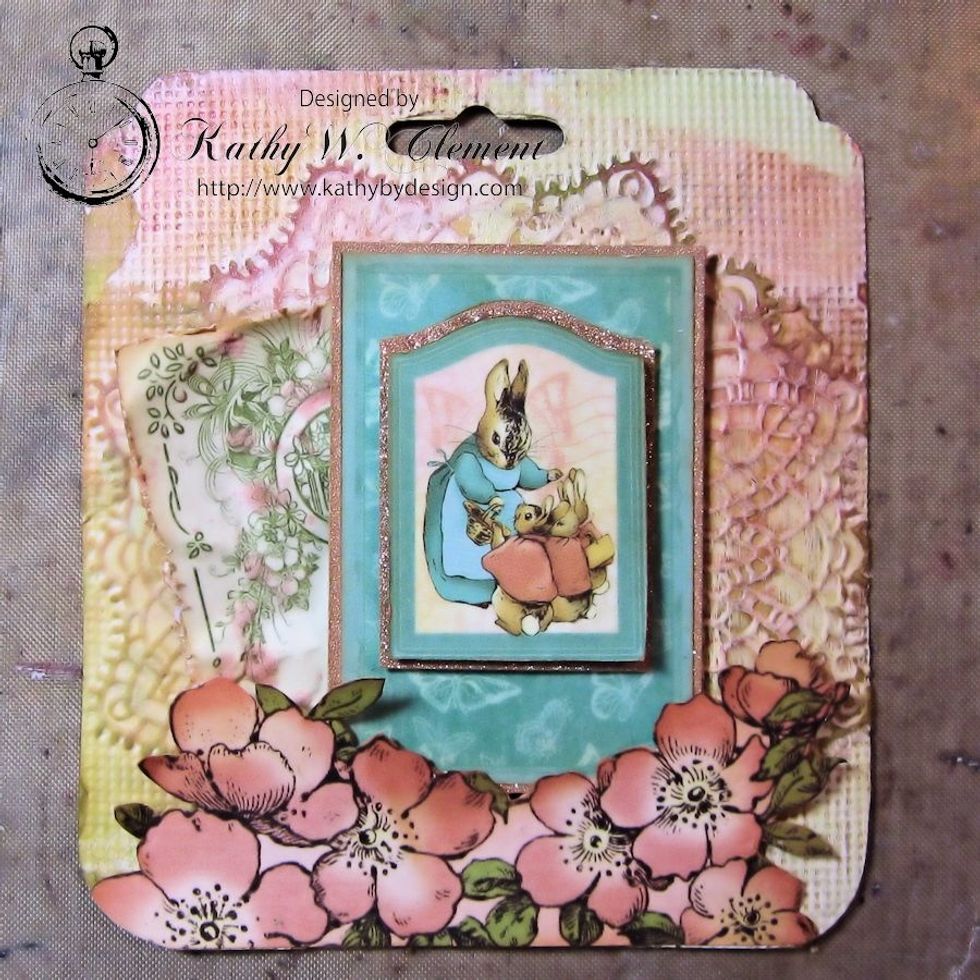 Use foam dimensional between the image and the frame, and again between the frame and the tag base. Glue the bottom edge under the fussy cut flowers.