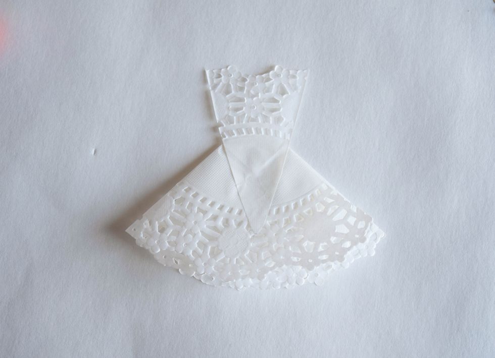 Use glue stick to glue the bottom of the bodice to the top of the skirt. You can also cut off the bottom pointy tip of the bodice before gluing it down. (This is the back of your dress)
