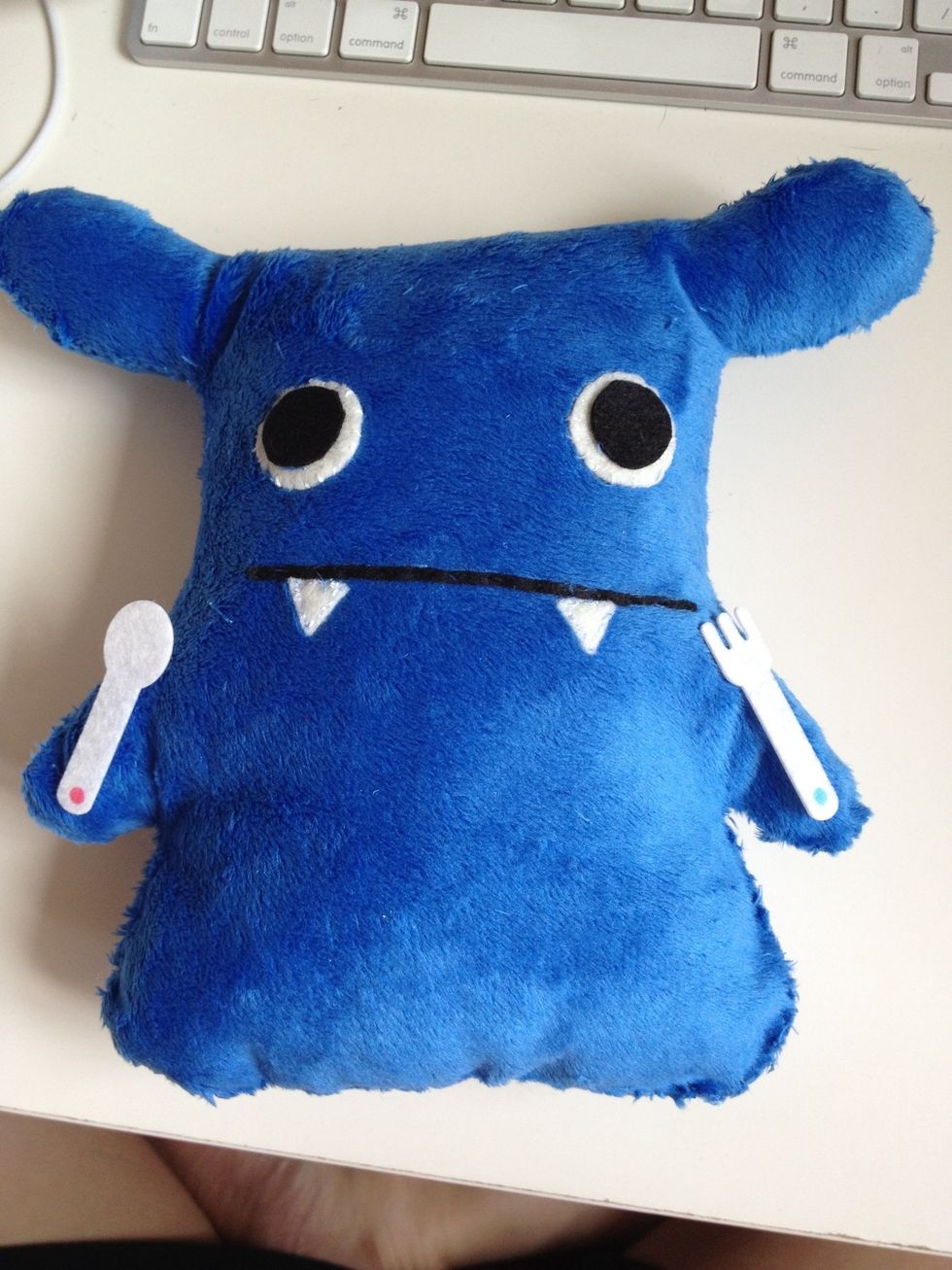 Use glue to adhere eyes to the doll's face and use running stitches to sew the mouth and teeth.