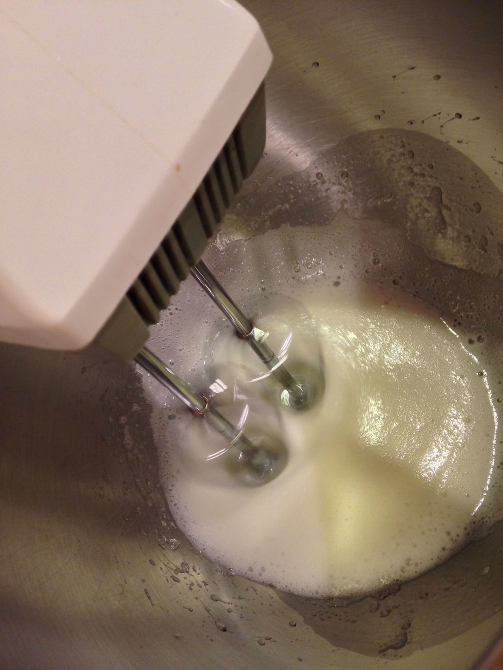 use half the egg whites that were  separated earlier and combine with the remaining two tablespoons of sugar in a mixing bowl. beat the egg whites until they are stiff and shiny.