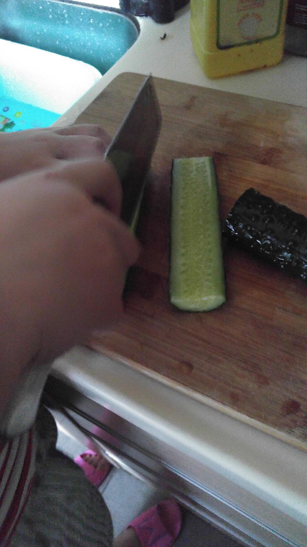 Use knife to cut the cucumber.