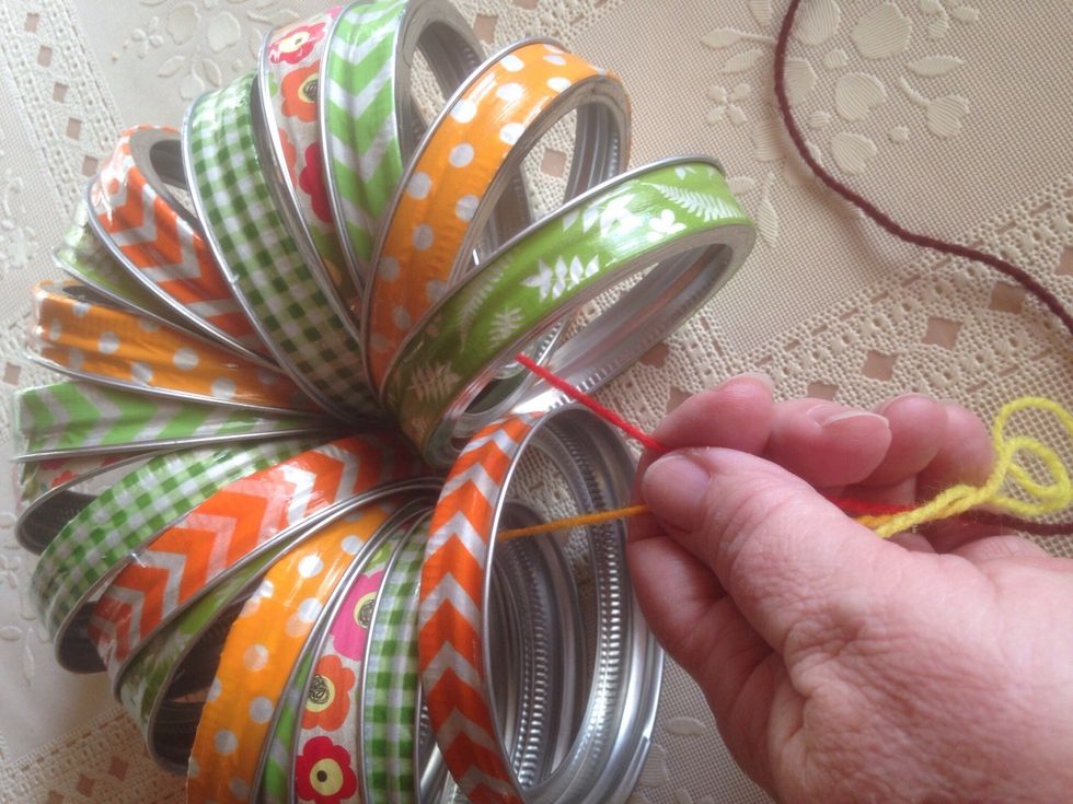 Use long strip of yarn to tie rings together. Pull yarn tight as possible, then knot.