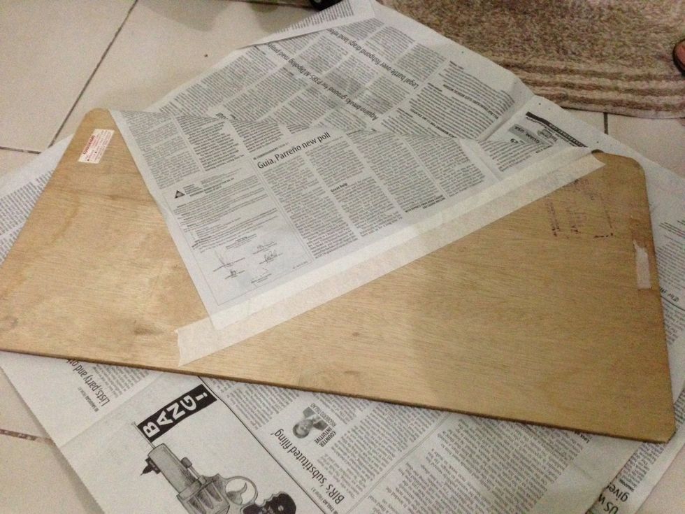 Use masking tape to stick newspaper to the corkboard.
