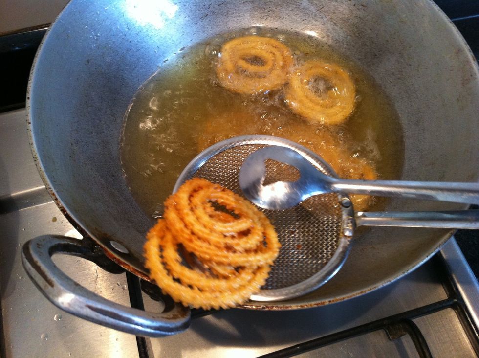 Use mesh spatula to lift the chakali from oil