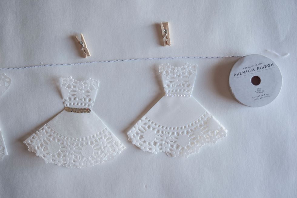 Use mini clothespins to clip the doily dresses to twine. You can even decorate the clothespins!