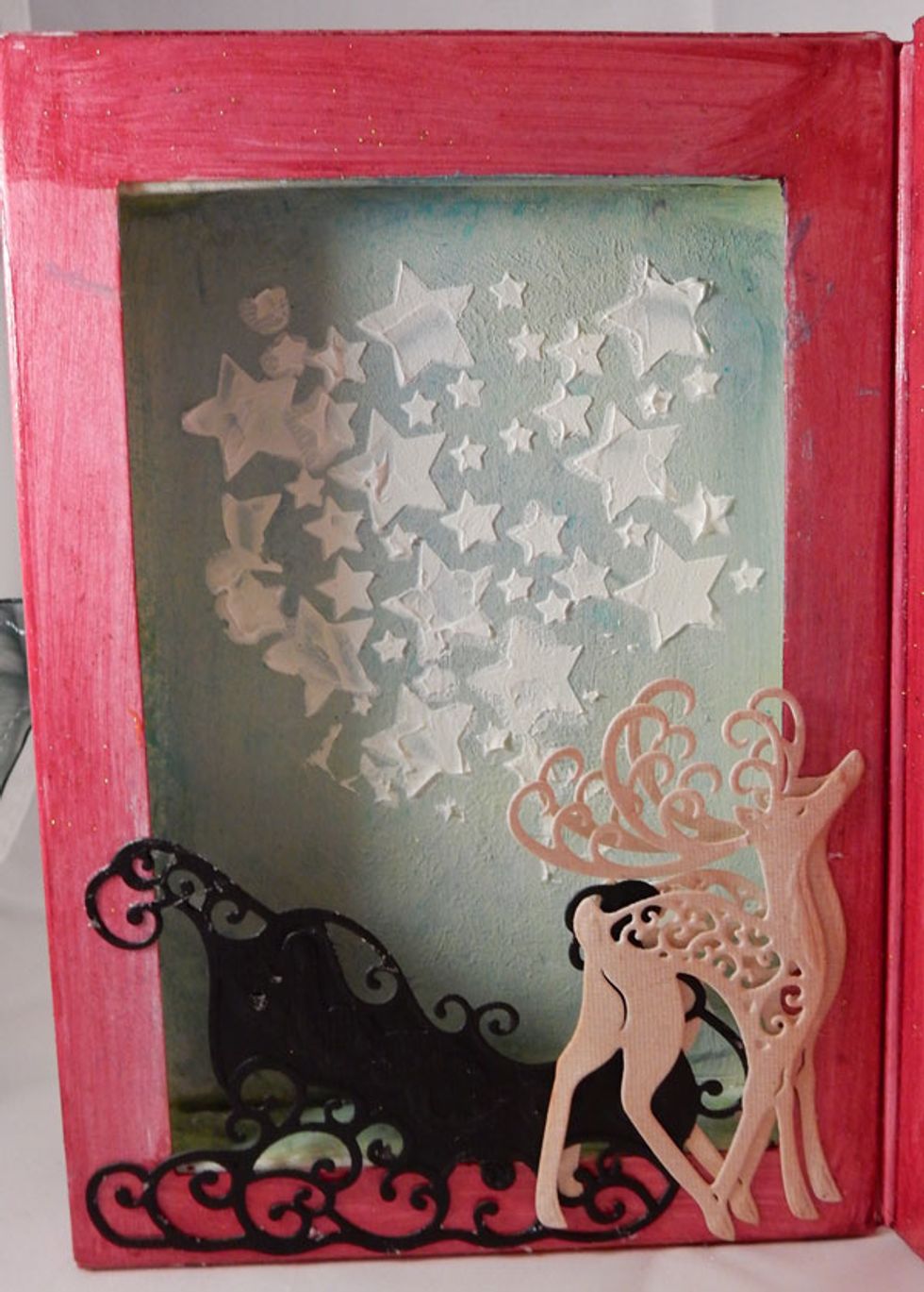 Use Mud Texture Paste with the Twilight Stencil to add stars to the left side.  Add die cut reindeer and sleigh.