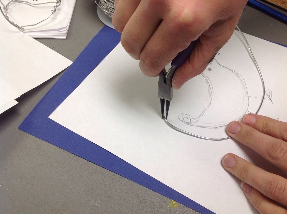 Use pliers to bend the wire around the outline of your drawing.
