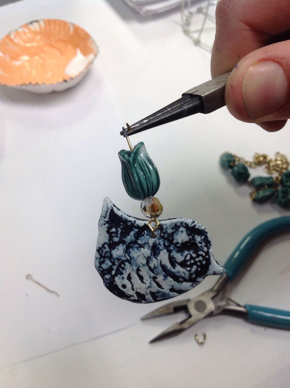 Use pliers to make a ring at the end of the wire so we can attach it to the cage.