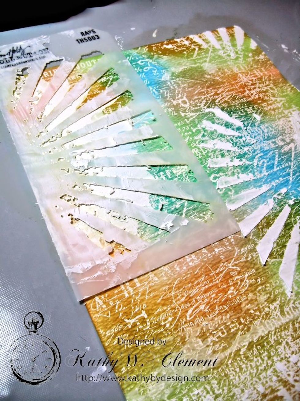 Use "Rays" stencil to add crackle texture over the top of the background, changing direction as you work. This creates a random pattern on the background. Apply with spatula knife or old credit card.