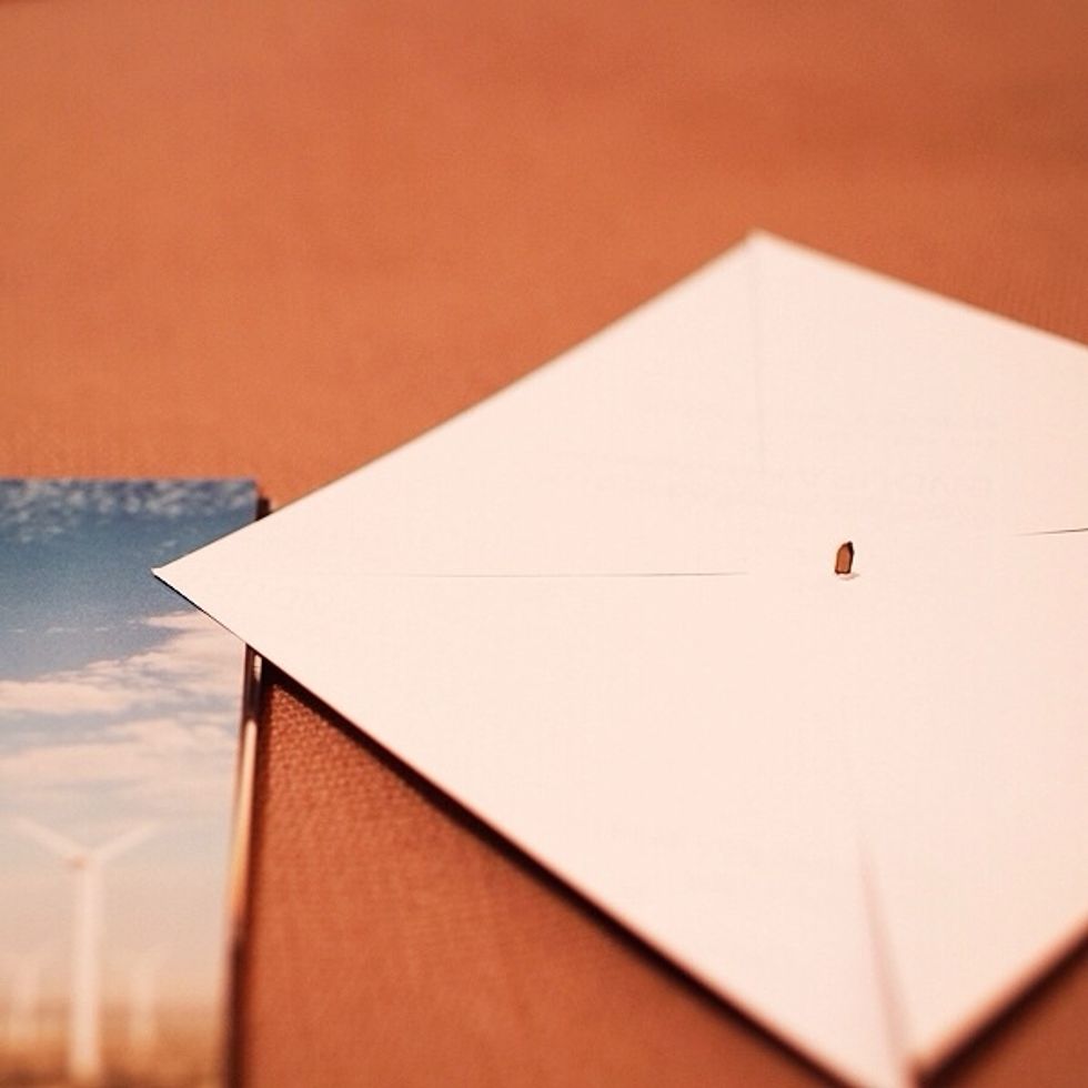 Use scissors & cut diagonally into the center of each Instagram print. You can measure if you want to be precise. Use one of the small brads & pierce it into the very center of the print.