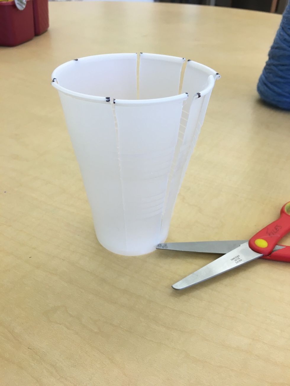 Use scissors to cut straight down the side by each dot to the bottom rim of the cup.