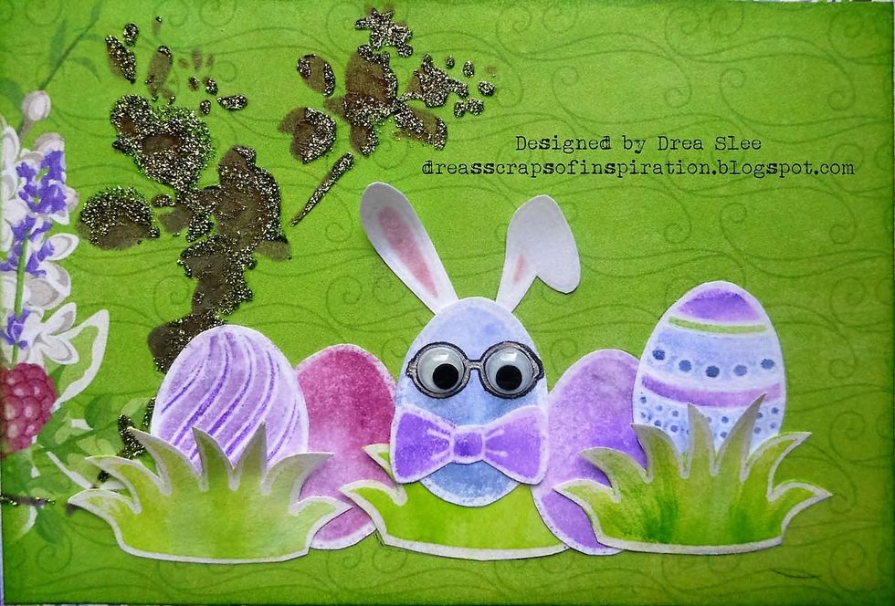 Use scissors to fussy cut your images, and glue onto the green paper as shown. Use black ink to stamp the glasses onto the center egg, and glue some googly eyes to it.