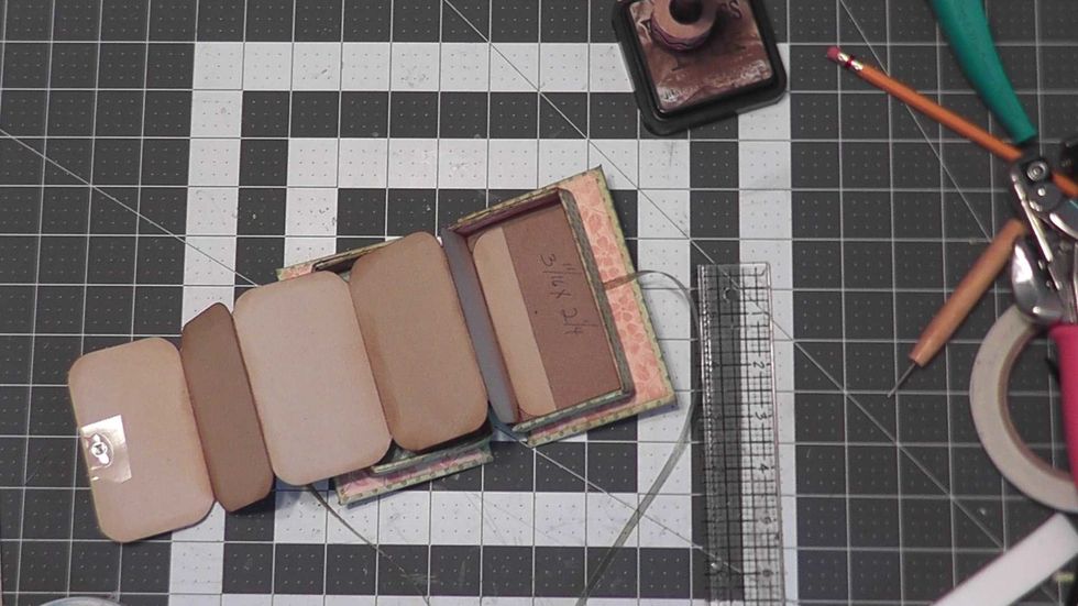 Use scor-tape or glue and attach the short tab into the right side of the box so that the pages easily fold into the right section.