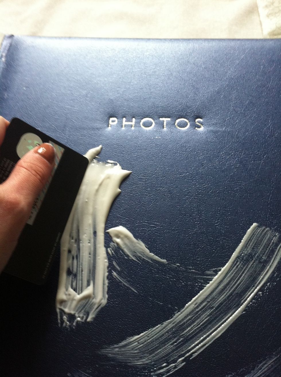 Use small amounts of modpodge and spread a thin even layer across the book, I used an old card