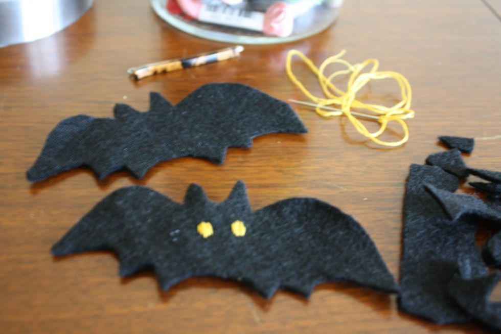 Use some yellow embroidery thread and sew a couple of eyes onto one of the bats.