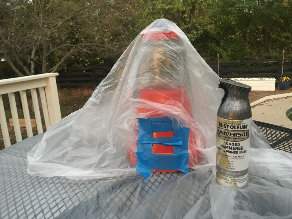 Use tape to outline a long box over a smaller box at the bottom of your pot and use plastic to cover the other part of the pot and jar, then spray paint it silver.