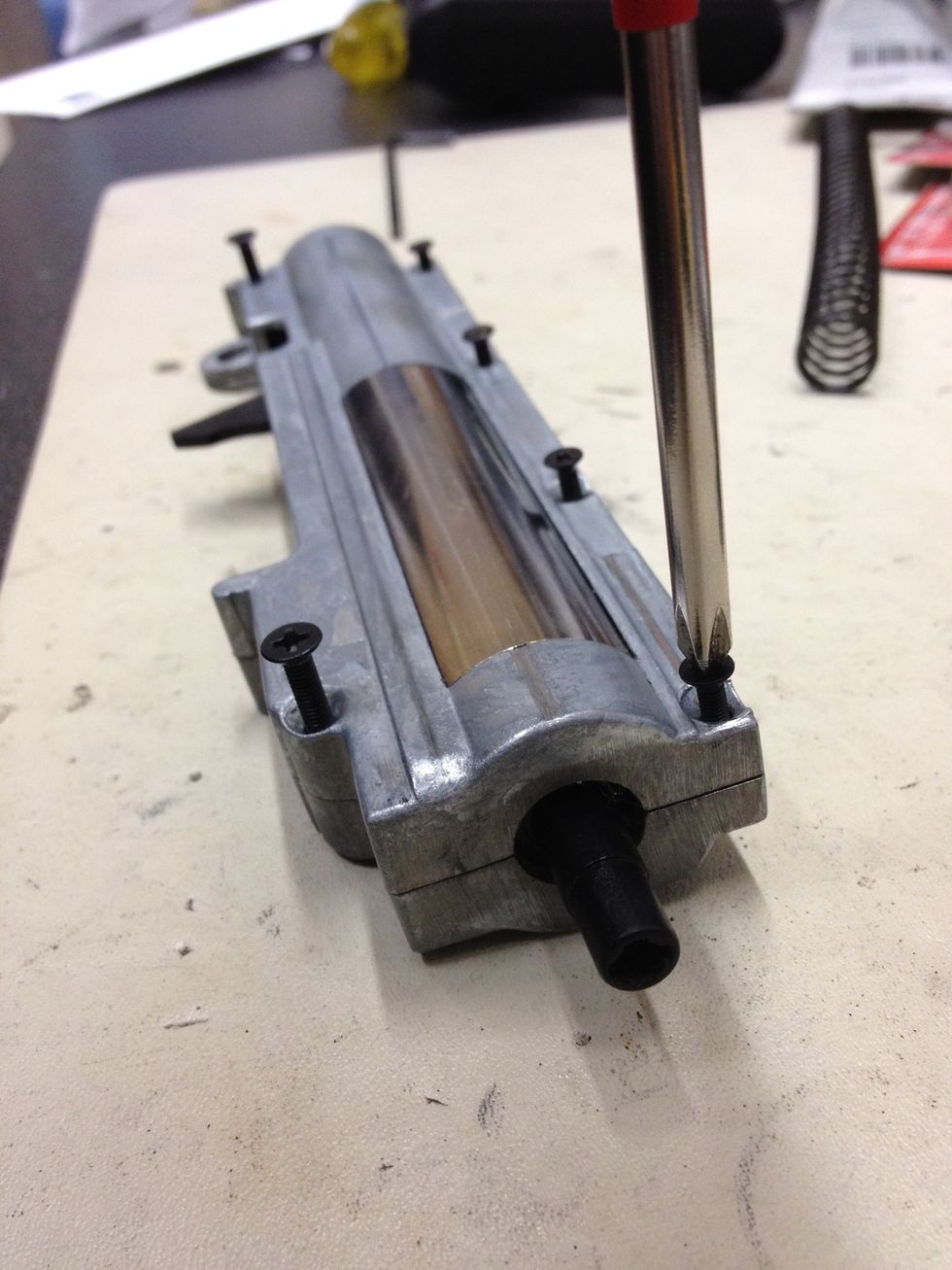 Use the #1 Phillips screwdriver to remove the 4 smaller screws on the top of the gearbox. Notice the size difference between the screws on the left vs. the smaller ones on the right?