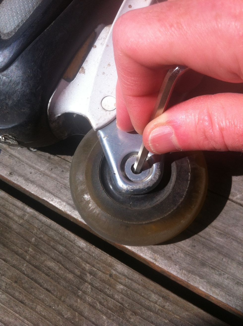 Use the allen wrench to poke the axel out through the wheel.