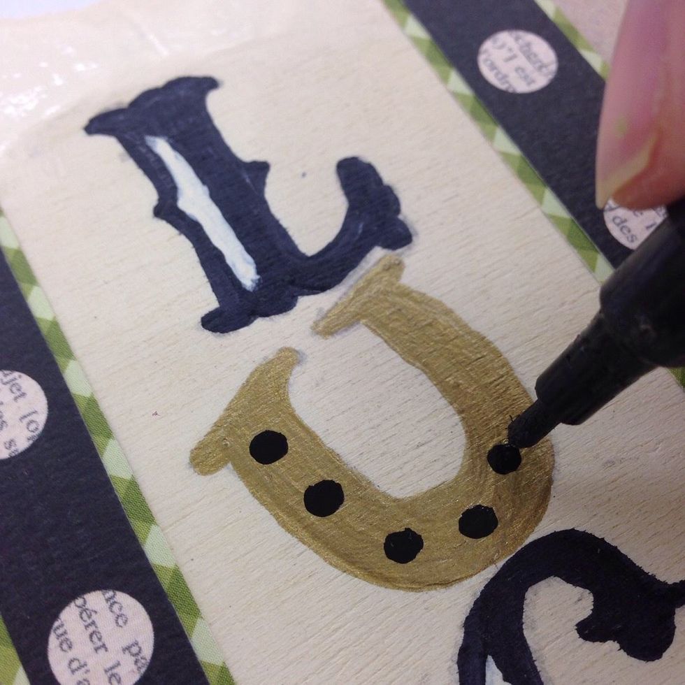 Use the black paint pen to add "nails" to the horse shoe U.
