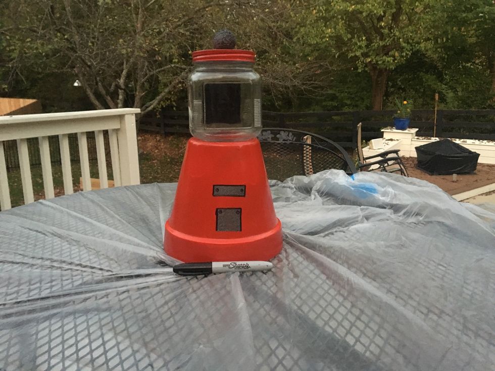 Use the black Sharpie and outline your two boxes when they are dried and put one dot on either sides of the smaller box at the top and one on each side of the long box.