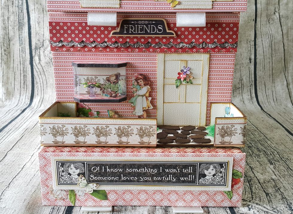 Use the cardstock scraps to make the door, add strips pattern cut out from papers for the garden fence.
