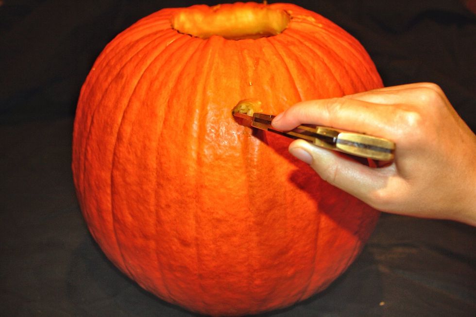 Use the carving knife 3/4 of the way up on the pumpkin and make a hole for the spout.