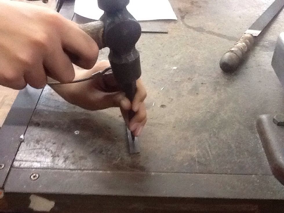 Use the centre punch and ball pein hammer again to punch a hole in the middle of the flatbar.